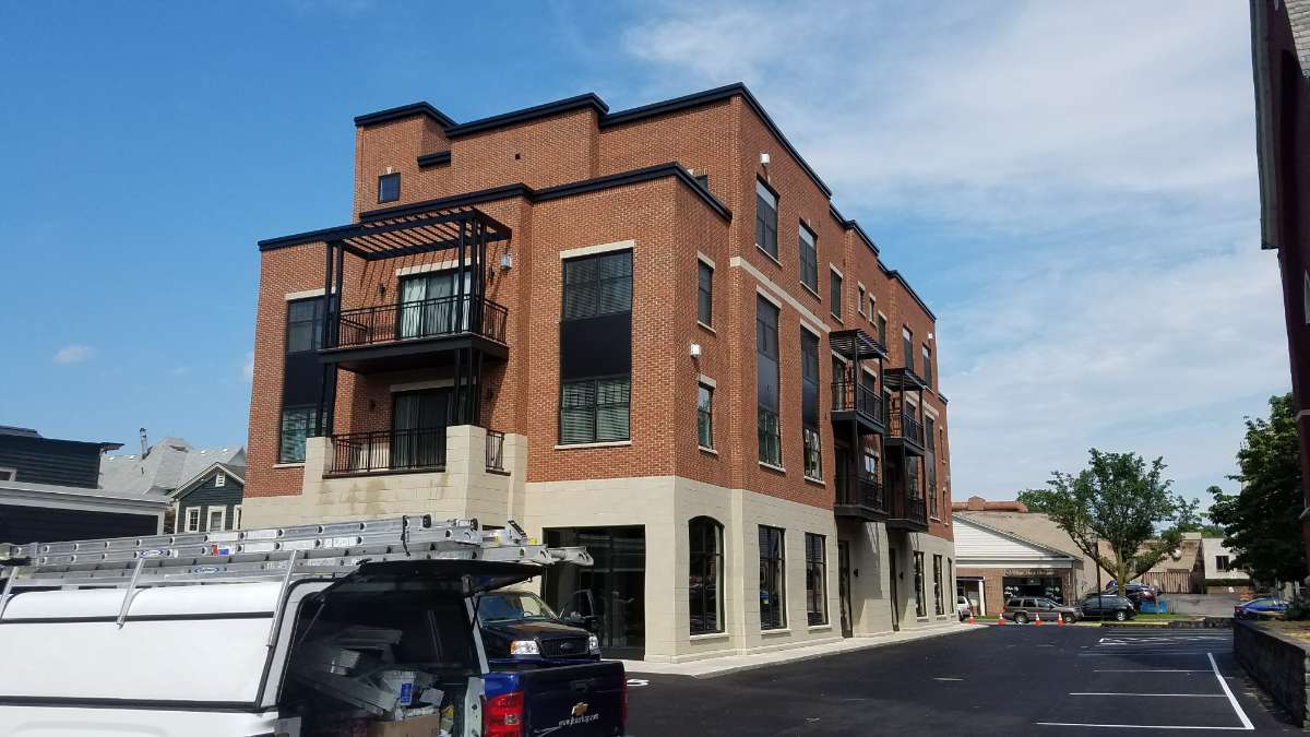 Modern brick building with balconies in urban setting.