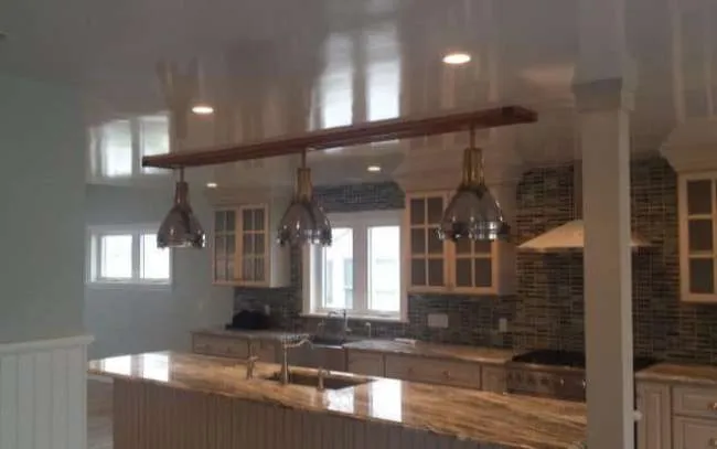Modern kitchen with pendant lights and marble countertops.
