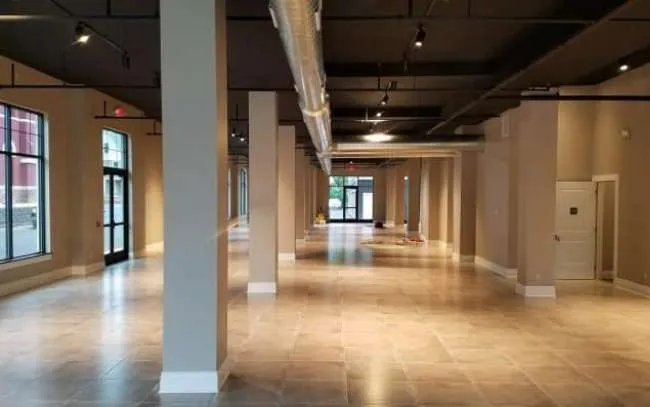 Spacious, modern empty gallery with columns and large windows.
